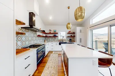 a kitchen with white cabinets and a large window at Mountain Sky in Granby