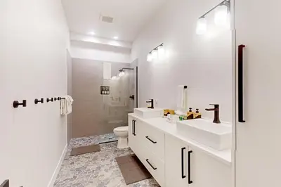 a white bathroom with two sinks and a shower at Mountain Sky in Granby