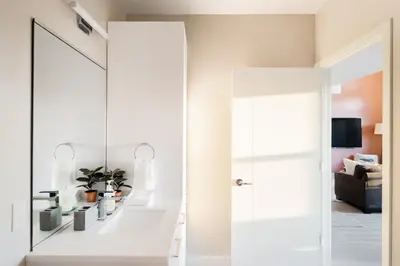 a mirror in a living room next to a door at Bold & Elevated | Espadin LoHi in Denver