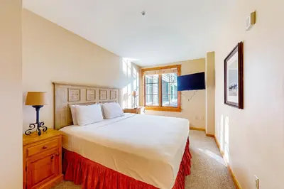 a bedroom with a large white bed and a window at Mountainside Majesty in Keystone