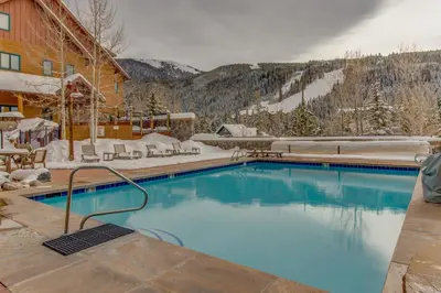 a swimming pool in the snow next to a building at Mountainside Majesty in Keystone