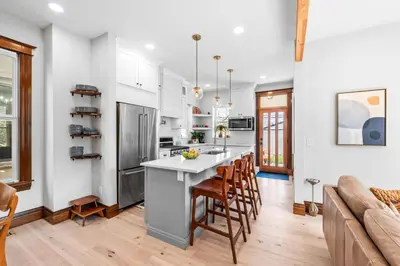 a kitchen with white cabinets and a kitchen island with bar stools at Race St - Denver in Denver