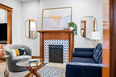 a living room with a fireplace and a couch and chairs at Race St - Denver in Denver