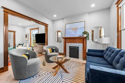 a living room with a blue couch and chairs and a fireplace at Race St - Denver in Denver