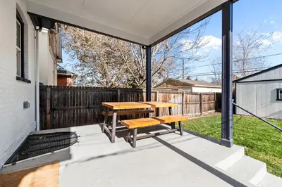 a patio with a wooden table and a bench at Race St - Denver in Denver