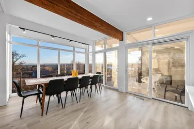 a dining room with a table and chairs and large windows at Lunceford - Northglenn in Northglenn