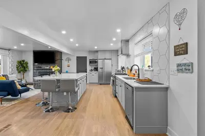 a kitchen with stainless steel appliances and a living room at Carr - Lakewood in Lakewood