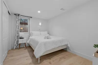a white bedroom with a bed and a window at Carr - Lakewood in Lakewood