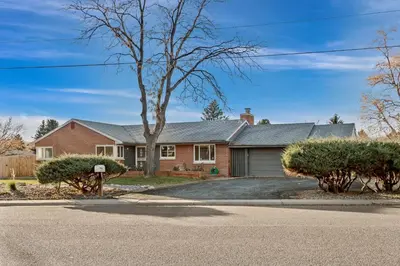 a red brick house with a tree in the driveway at Carr - Lakewood in Lakewood