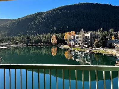 a view of a lake with a house and trees at Keystone Lakeside Condo in Keystone