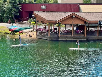 two people are standing on surfboards in the water at Keystone Lakeside Condo in Keystone