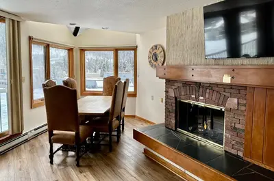 a dining room with a table and a fireplace at Keystone Lakeside Condo in Keystone