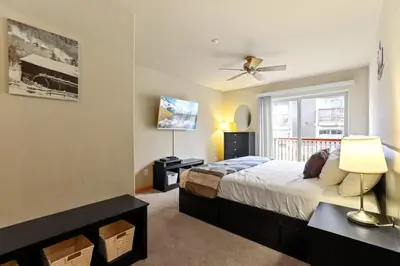 a bedroom with a bed with a ceiling fan and a window at 2BR Condo - Ideal Hub for Year-Round Fun in Silverthorne
