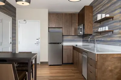 a kitchen with wooden cabinets and a refrigerator at Residence Inn by Marriott Arvada Denver West in Arvada