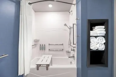 a bathroom with a bath tub and a bench in it at Residence Inn by Marriott Arvada Denver West in Arvada