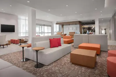 a living room with a couch and some tables and chairs at Hilton Garden Inn Denver Airport Tower Road in Denver