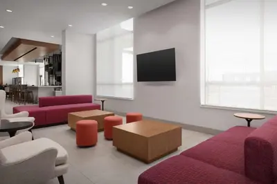 a living room with red furniture and a flat screen tv at Hilton Garden Inn Denver Airport Tower Road in Denver