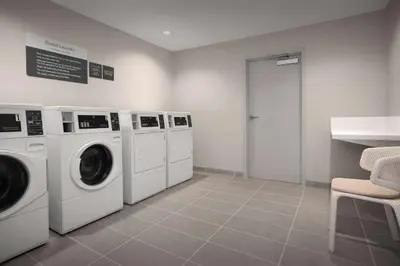 a laundry room with three washing machines and a counter at Hilton Garden Inn Denver Airport Tower Road in Denver