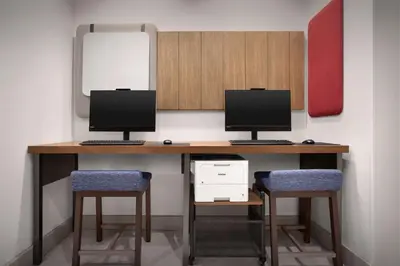 two monitors on a desk with two chairs at Hilton Garden Inn Denver Airport Tower Road in Denver