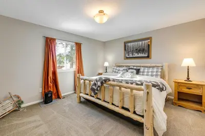 a bedroom with a wooden bed and a window at Loveland Home with Private Hot Tub and Wood Fireplace! in Loveland