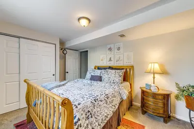 a bedroom with a bed and a night stand with a lamp at Loveland Home with Private Hot Tub and Wood Fireplace! in Loveland