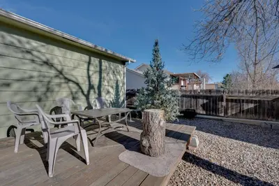 a wooden deck with a table and chairs on it at Loveland Home with Private Hot Tub and Wood Fireplace! in Loveland