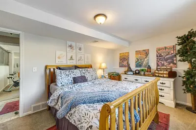 a bedroom with a wooden bed and a staircase at Loveland Home with Private Hot Tub and Wood Fireplace! in Loveland
