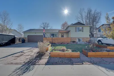 a house with a yard with some plants at Loveland Home with Private Hot Tub and Wood Fireplace! in Loveland