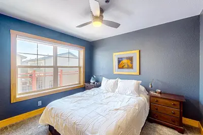 a blue bedroom with a bed and a window at La Rive Del Lago 302 in Dillon