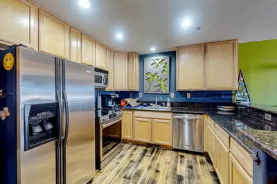 a kitchen with wooden cabinets and a stainless steel refrigerator at La Rive Del Lago 302 in Dillon