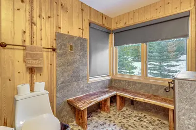 a bathroom with a toilet and a window at Lake and Mtn Views Spectacular Grand Lake Home in Grand Lake
