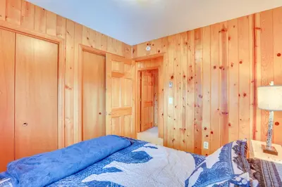 a bedroom with wood paneled walls and a bed at Lake and Mtn Views Spectacular Grand Lake Home in Grand Lake