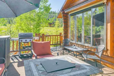 a screened in porch with chairs and a grill at Lake and Mtn Views Spectacular Grand Lake Home in Grand Lake