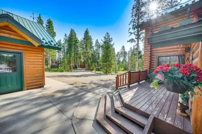 a wooden deck with a bench and flowers on a cabin at 4 Mi to Rocky Mtn Natl Park Cabin Near Town! in Grand Lake