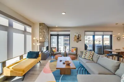 a living room with a couch and a table at Winter Park Condo with Hot Tub, Balcony and Shuttle! in Winter Park