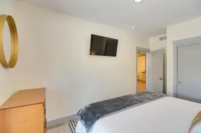 a bedroom with a bed and a tv on the wall at Winter Park Condo with Hot Tub, Balcony and Shuttle! in Winter Park