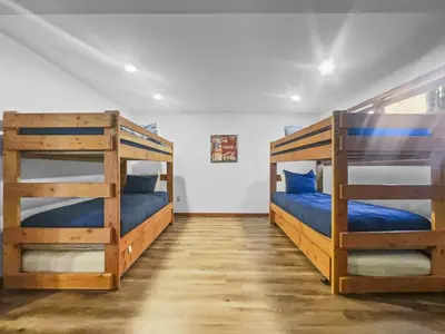 two bunk beds in a room with blue pillows at 208 Tenderfoot 5Br 5Ba home in Dillon