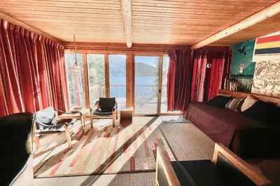 a living room with a couch and chairs and windows at Davis Cabin, Historic Charmer in Grand Lake