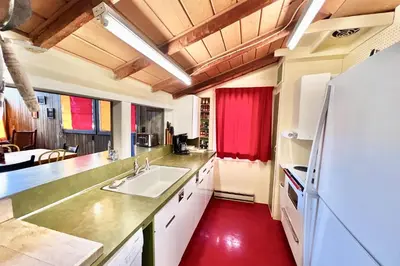 a kitchen with a white sink and a red floor at Davis Cabin, Historic Charmer in Grand Lake