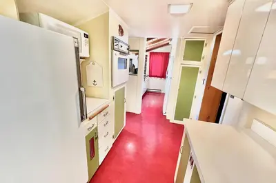 a kitchen with a red floor and white appliances at Davis Cabin, Historic Charmer in Grand Lake
