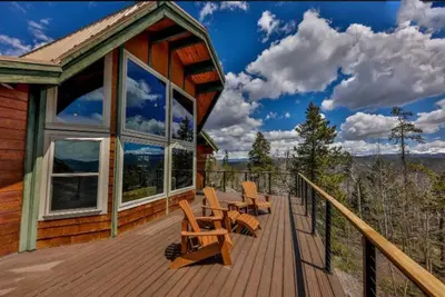 a wooden deck with chairs and tables on a house at 273 Fallen Rock in Tabernash