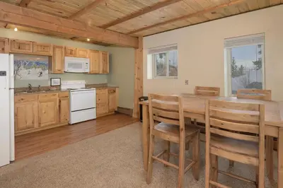 a kitchen with wooden cabinets and a table and chairs at 273 Fallen Rock in Tabernash