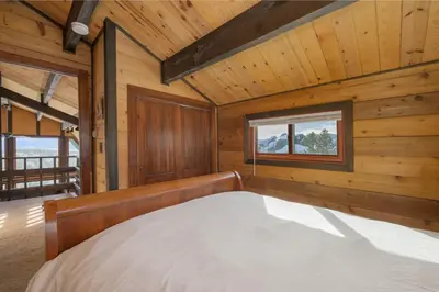 a bedroom with a bed in a wooden cabin at 273 Fallen Rock in Tabernash