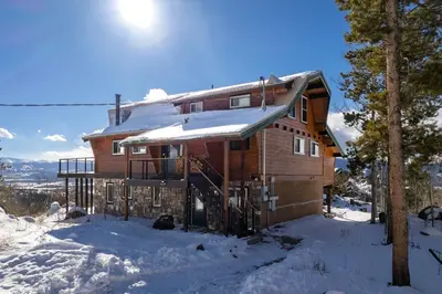 a log cabin in the snow with snow at 273 Fallen Rock in Tabernash
