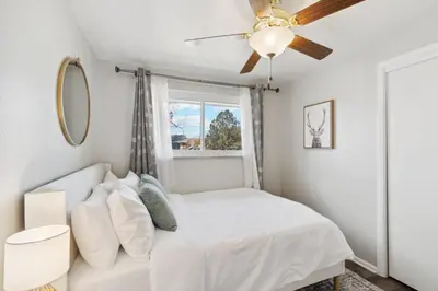 a bedroom with a white bed and a ceiling fan at NEW • Modern • 4BR • Game Rm • Ping-Pong in Arvada