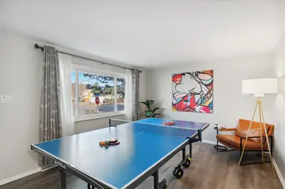 a blue ping pong table in a room with a window at NEW • Modern • 4BR • Game Rm • Ping-Pong in Arvada