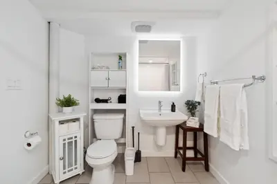 a white bathroom with a toilet and a sink at NEW • Modern • 4BR • Game Rm • Ping-Pong in Arvada