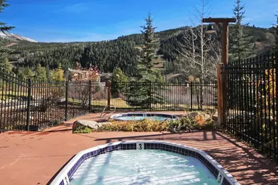 a hot tub in a yard with a fence at 2656 Tenderfoot Lodge condo in Keystone