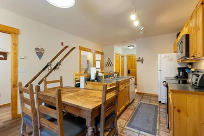 a kitchen with a wooden table and a refrigerator at 2656 Tenderfoot Lodge condo in Keystone