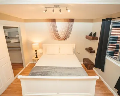 a bedroom with a white bed and a window at Windsor Retreat Private Basement Suite in Denver